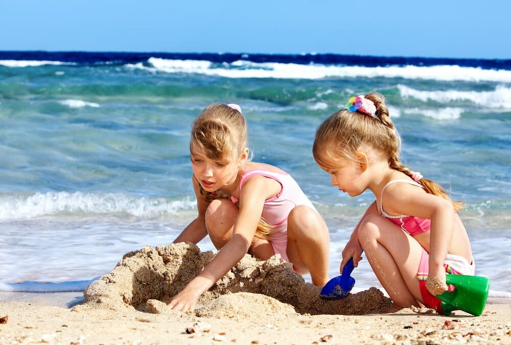 Kinder spielen im Familienurlaub am Strand