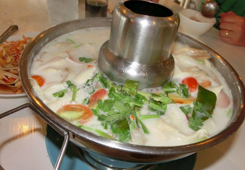 Thai Gericht Tom Kha Gai - Kokossuppe mit Huhn im beheizten Hut